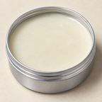 Close-up of the pale cream inside the metal MAISON RODIN Care Cream tin