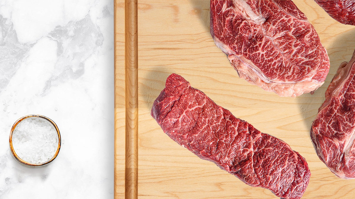 Steaks on a Maison Rodin maple cutting board with juice groove