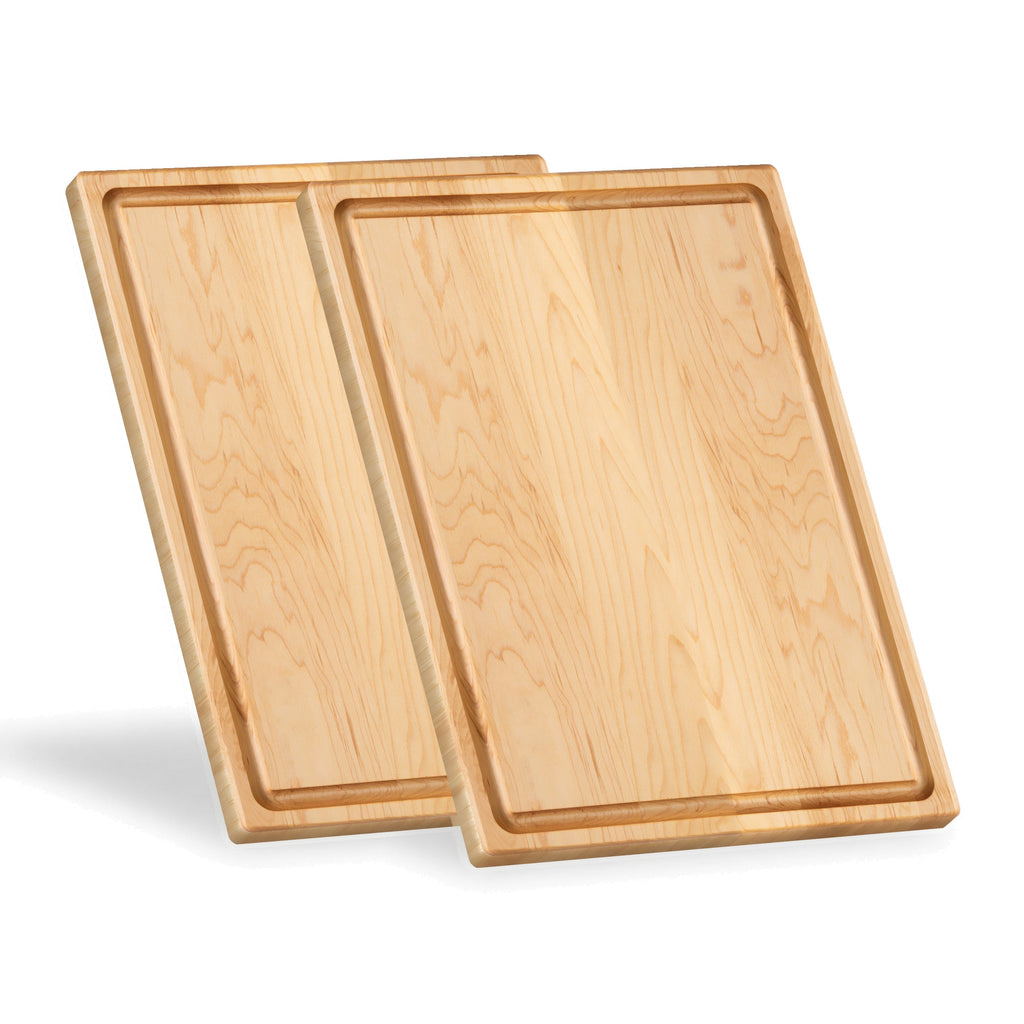 Two maple cutting boards with juice grooves standing on their short edges