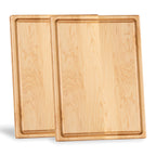 Two maple cutting boards with juice grooves standing on their short edges