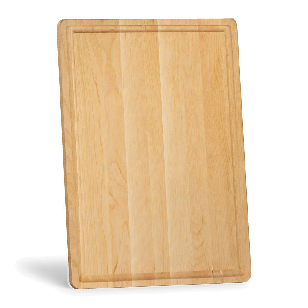 Maple cutting board with a juice groove standing on its short edge, viewed at an angle