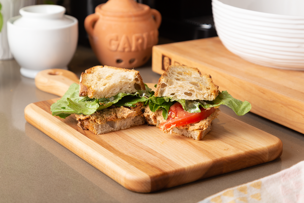 Large maple serving board with handle, 16 × 8 in with a tuna salad sandwich