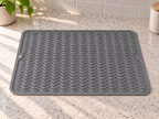 Grey silicone mat laid flat, with wavy ridges, rounded corners and a hanging hole